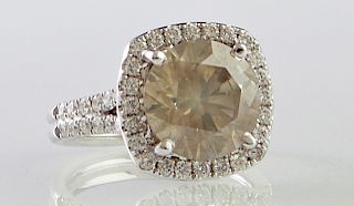 Lady's 18K White Gold Dinner Ring, with a 4.9 carat fancy yellow brown round diamond, atop a border of round diamonds, the split shoulders of the band