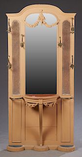French Polychromed Mahogany and Cane Hall Stand, c. 1910, the stepped arched top over a central arched wide beveled mirror flanked by carved panels an