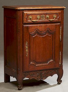 French Louis XV Style Carved Oak Confiturier, 19th c., the rounded edge and corner top above a frieze drawer, over a fielded panel cupboard door with 