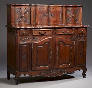 French Louis XV Style Carved Oak Buffet a Deux Corps, mid 20th c., the serpentine upper section with a central cupboard flanked by two sliding door cu