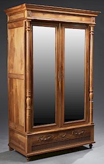 French Provincial Style Carved Walnut Armoire, 19th c., the stepped crown above setback double beveled mirror doors flanked by turned tapered fluted c