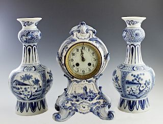 Three Piece Delft Pottery Clock Set, late 19th c., consisting of a bulbous clock with blue floral decoration and a windmill scene beneath the enamel d