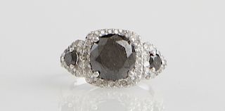 Lady's 14K White Gold Dinner Ring, with a large round natural black diamond atop a border of round white diamonds, flanked by two triangular lugs with