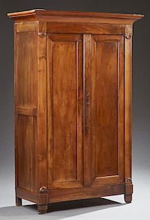 French Louis Philippe Carved Walnut Armoire, c. 1850, the stepped ogee crown over double doors flanked by flat pilasters, on a plinth base with block 