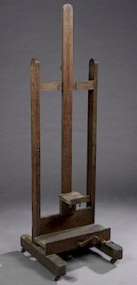 French Carved Oak Adjustable Artist's Easel, 19th c., on a splayed leg base joined by a stretcher, on wooden wheels, H.- 71 in., W.- 21 3/8 in., D.- 2
