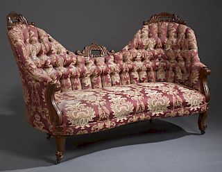 American Carved Walnut Double Chair Back Settee, late 19th c., the serpentine back with three pierced leaf carved crests over a tufted back and rolled