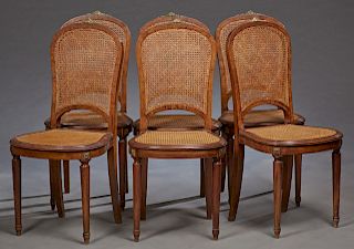 Set of Six French Louis XVI Style Ormolu Mounted Carved Walnut Caned Dining Chairs, 20th c., the arched caned backs over bowed cane seats, on turned t