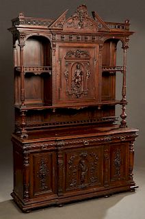 French Henri II Style Carved Oak Buffet a Deux Corps, c. 1880, with an arched shell and Northwind crest flanked by spindled balusters, above a breakfr