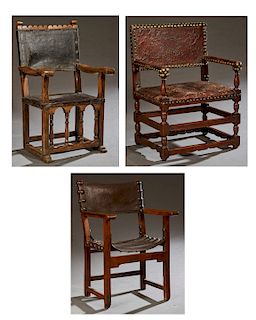 Group of Three Spanish Provincial Carved Walnut Leather Upholstered Arm Chairs, early 19th c., with large iron tack decoration, one with a sling seat;
