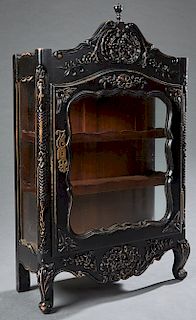 Diminutive French Louis XV Style Ebonized Mahogany Vitrine, late 19th c., the arched floral carved crest over a shaped glazed door with iron butt hing