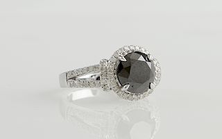Lady's 14K White Gold Dinner Ring, with a round 3.06 carat black diamond atop a border of round white diamonds, the split sides of the band mo