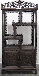 A Chinese Carved Hardwood Etagere, Height 46 1/2 x width 23 x depth 10 1/2 inches.
