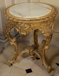 Louis XV style gilt round table having inset onyx top with carved edge and frieze and cabriole legs with stretcher, 19th century. 
h...