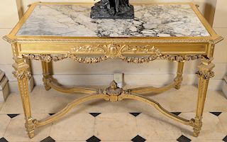 Gilt center table having inset grey and white marble top on decorated frieze on four sided legs and stretcher base with urn finial (...
