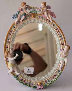 German porcelain oval mirror mounted with putti. 
13 1/2" x 10 1/2" 
***If this lot is not picked up on Sat. 9/22, Sun. 9/23, or Tue...
