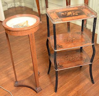 Two stands to include a Victorian marquetry inlaid three tier stand with ebonized legs and brass gallery and a small inlaid round cu...