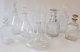 Group of seven crystal decanters with ground bottoms to include squat vase decanter, decanter with etched giraffe, and five other de...