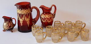 Thirteen piece lot of inlaid gold crystal including three cranberry pitchers plus ten small handled cups. 
cups: height 2 inches 
**...