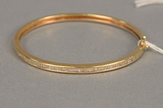 Gold bangle bracelet set with inline emerald cut diamonds. 12.7 grams