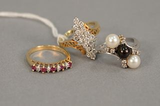 Three 14 karat gold rings set with diamonds, pearls, and red stones, 13.6 grams.