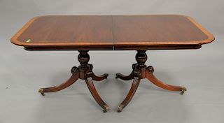 Mahogany double pedestal dining table with banded inlaid top and two 21 inch leaves. top: 44" x 68", opens to 110in.