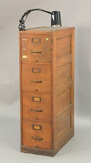 Oak four drawer file cabinet. ht. 52 in., wd. 15 in., dp. 27 in.