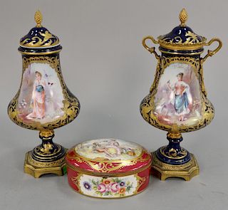Three piece lot to include Pair of Sevres urn with hand painted panel (one missing metal mounts) and an oval covered box. urn: ht. 12 1/2in., box: lg.