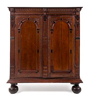 A Continental Carved Oak Cupboard Height 62 3/4 x width 53 1/2 x depth 24 1/2 inches.