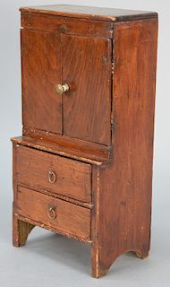 Miniature cabinet/secretary Bath, Maine, with two doors over two drawers on boot jack ends with traces of old white wash, now refini...