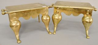 Two heavy brass footmen with two handles and downswept legs.  height 9 3/4 in., length 20 in.  height 10 1/2 in., length 20 in.