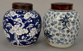 Two blue and white Chinese ginger jars, one apple blossom tree and the other having scrolling vine and flower design, both with wood...