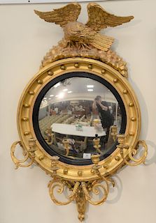 Girandole convex mirror mounted with carved eagle and four candle holders, 19th century.  height 45 in., diameter 25 1/2 in.