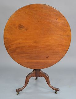 Mahogany tip table on urn turned shaft, set on tripod base. 
height with wheels 28 1/4 in., diameter 34 in.