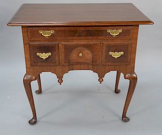 Queen Anne walnut lowboy having overhanging top over one long drawer over three short drawers, center drawer with arched concave cen...