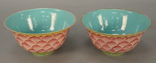 Pair of Chinese famille rose bowls, pink lotus enameled petals around exterior, blue glazed ground interior, bottoms marked with ora...