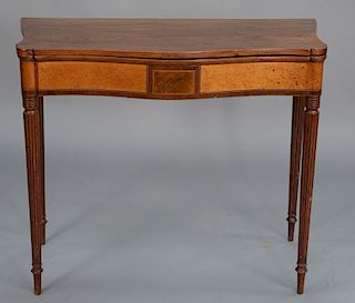 Sheraton mahogany game table having serpentine top with birdseye maple panels, set on turned and fluted legs, circa 1830. 
height 30...