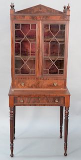 Sheraton mahogany two part cabinet on fluted legs, circa 1830. 
height 64 1/2 in., case width 24 1/4 in.