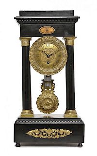 An Empire Style Gilt Bronze Mounted Ebonized Portico Clock, Height 18 1/4 inches.