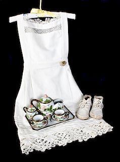 A Porcelain Childs Tea Set, Length of apron 25 inches.