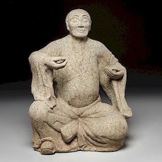 Japanese stone carving of a seated monk