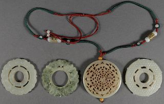 FOUR CHINESE CARVED JADE DISC FORM PENDANTS QING