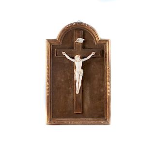 Cristo crucificado. Francia, finales del siglo XIX. Talla en marfil. Con marco de madera dorada y tericipelo color verde. Firmado.
