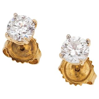 A pair of diamond 18K and 14K yellow gold stud earrings.