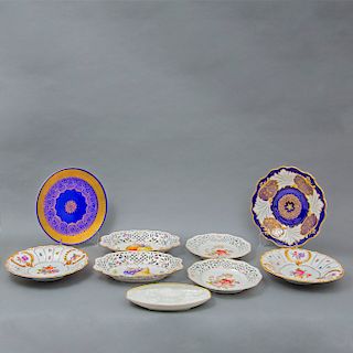 Lote de 9 platos decorativos. Alemania. Siglo XX. Elaborados en porcelana de Bavaria. Algunos con diseños calados. Con esmalte dorado.