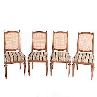 Juego de 4 sillas. S. XX. Elaboradas en madera tallada. Con respaldo en bejuco tejido, asiento en tapicería a rayas y soportes cónicos.