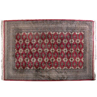 Alfombra. Origen iraní Siglo XX. Estilo Tekke. Elaborada a mano en fibras de lana y algodón. Decorada con motivos geométricos.