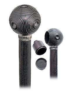 59. Ebony Puzzle Container Cane -Ca. 1880 -Ebony ball knob turned with five identical, concentric circles panels, plain silver collar and an ebony sha