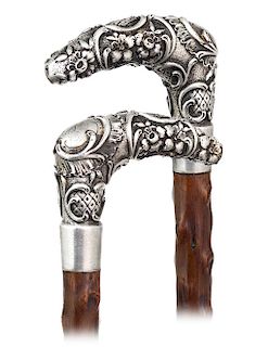 88. Silver Day Cane -Ca. 1890 -L-shaped silver handle modeled with pleasing rounded edges and hand chased in a rich Baroque taste with dense scrolls, 
