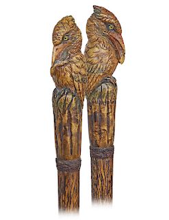158. Kingfisher Cane -Ca. 1920 -Large boxwood handle carved as a kingfisher with glass eyes and a fish in its long beak, braided leather collar, feath