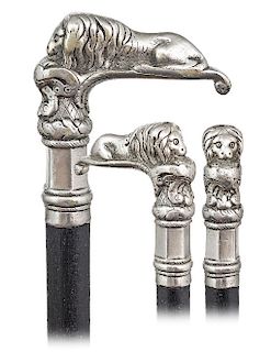 164. Lion Knobkerrie Cane -Ca. 1870 -L-shaped and heavy cast white metal lion cane, ebony shaft and a metal ferrule. The prone lion comes on an elabor